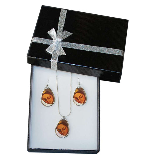 Jewellery set with amber-coloured artwork in a black gift box with a silver ribbon.