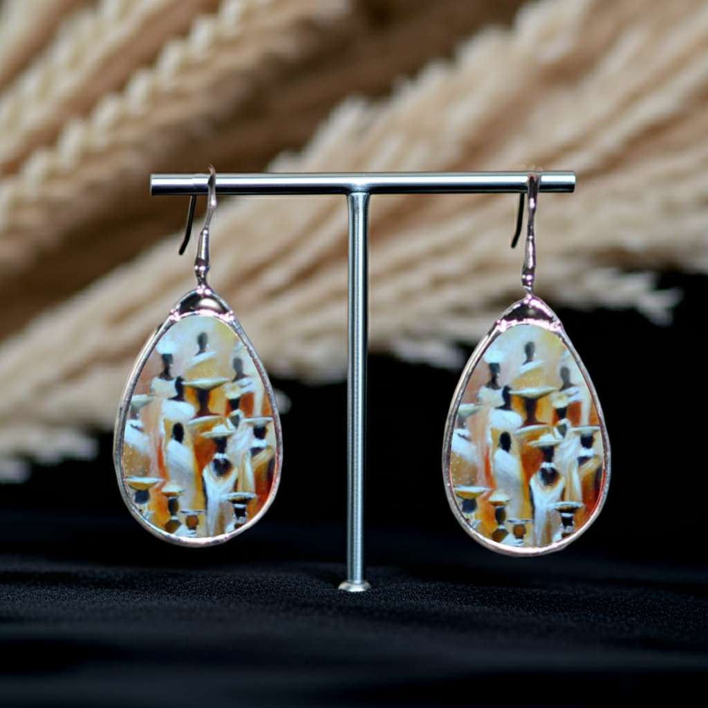 Teardrop-shaped earrings on a stand with a natural background
