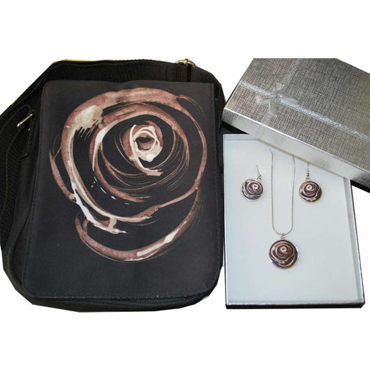 Black bag with rose design next to jewelry set in a box